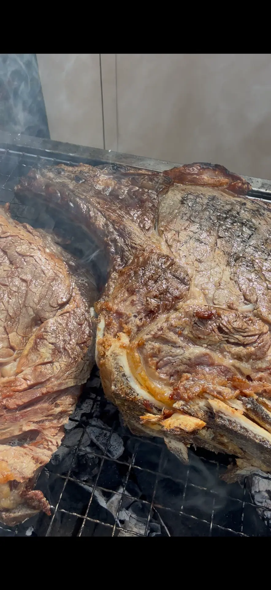 Grote stukken vlees op de houtskoolgrill