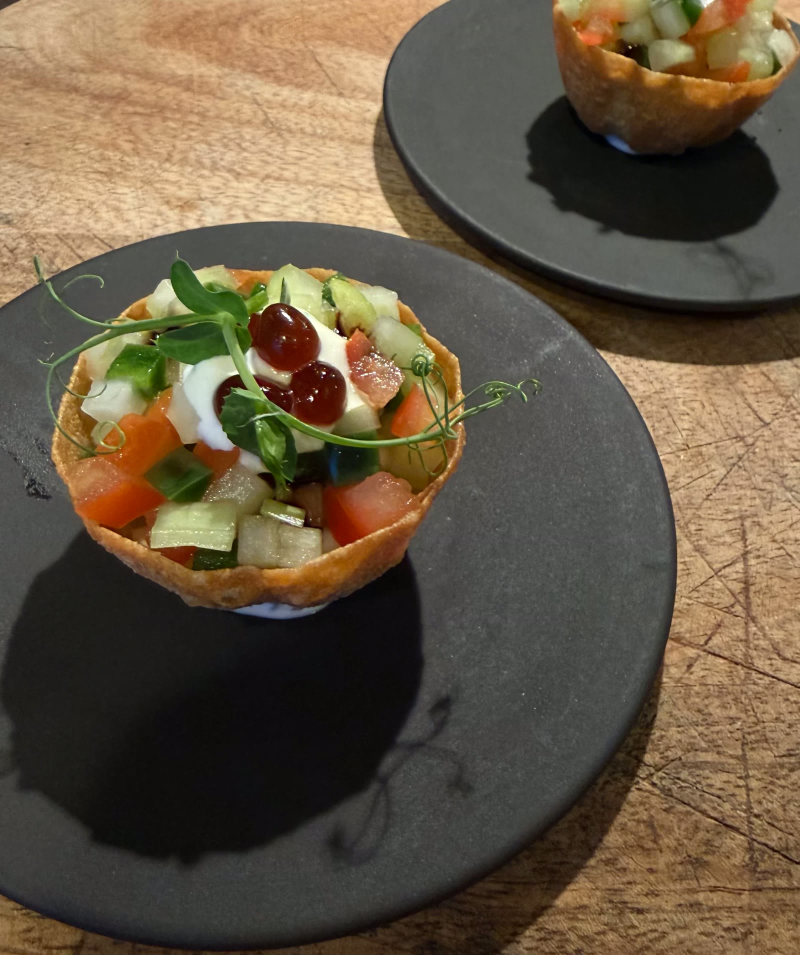 Amuse in een krokant bakje met tomaat en komkommer